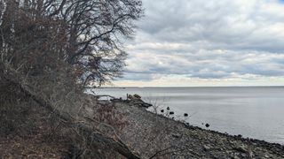 The still water of the way, clouds are overhead and it is dark.