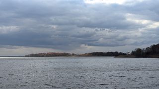 Across the bay is a piece of land with trees still showing their orange and red leaves.